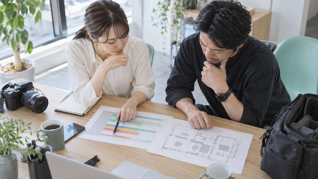 撮影予定と場所の図を机上で照らし合わせる担当者たち